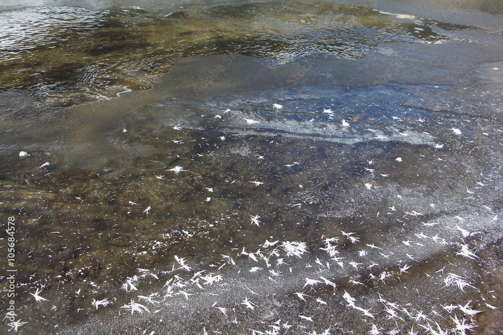 Obraz premium Fancy outgrowths of hoarfrost on ice of the thawing river in the spring
