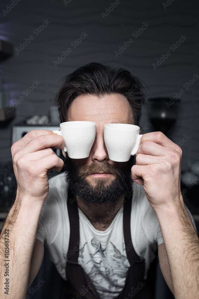 bartender keeps cups of coffee near face; bartender keeps cups of coffee near face;