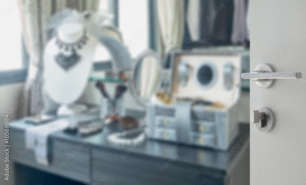 Fototapeta premium opened white door to blurred wooden dressing table with accessories at home
