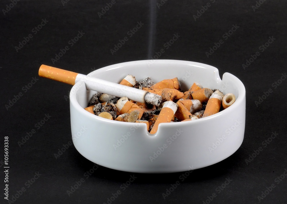 White ceramic ashtray full of smokes cigarettes White ceramic ashtray full of smokes cigarettes