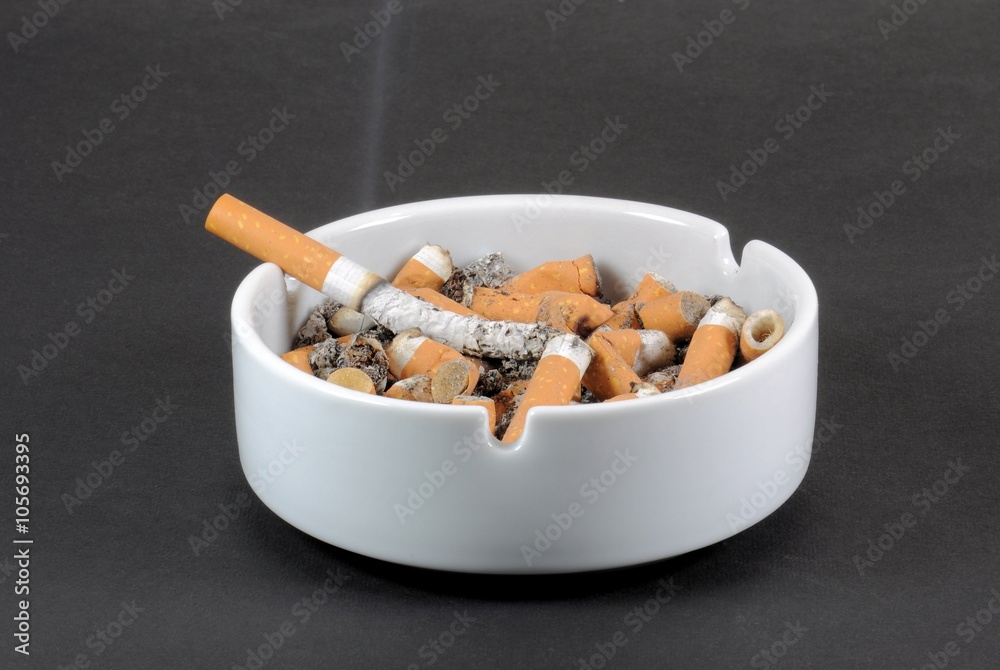White ceramic ashtray full of smokes cigarettes White ceramic ashtray full of smokes cigarettes