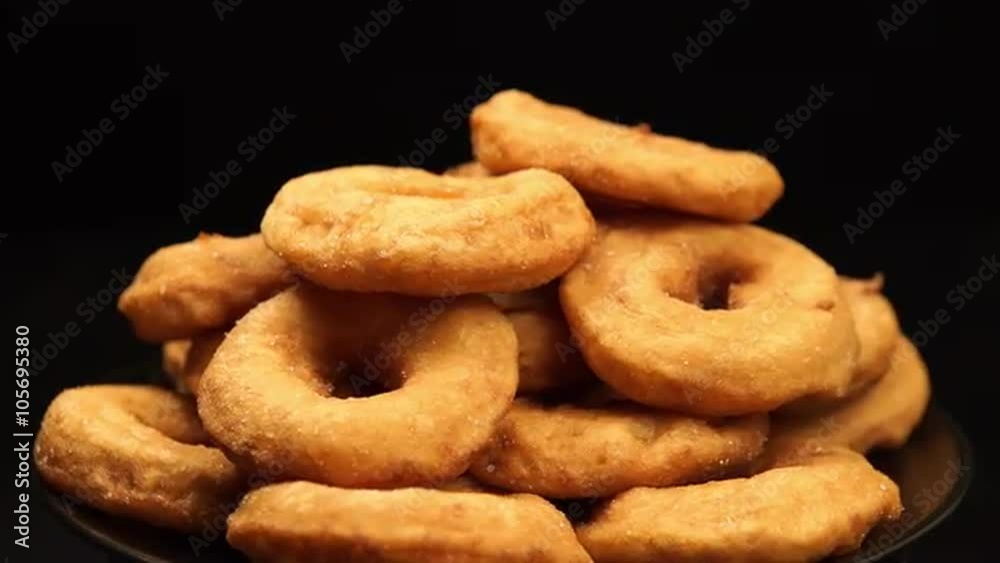 ROTATION: A pile of the doughnuts rotation on a black background ROTATION: A pile of the doughnuts rotation on a black background