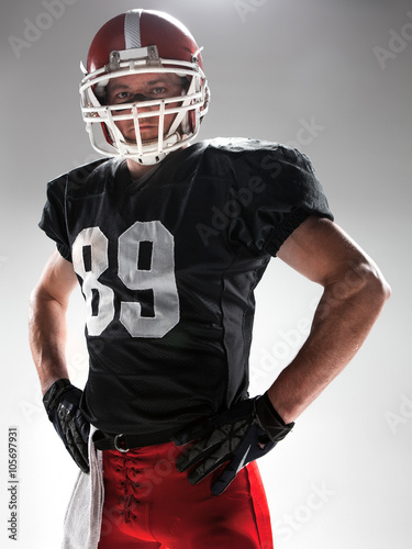 American football player posing with ball on white background