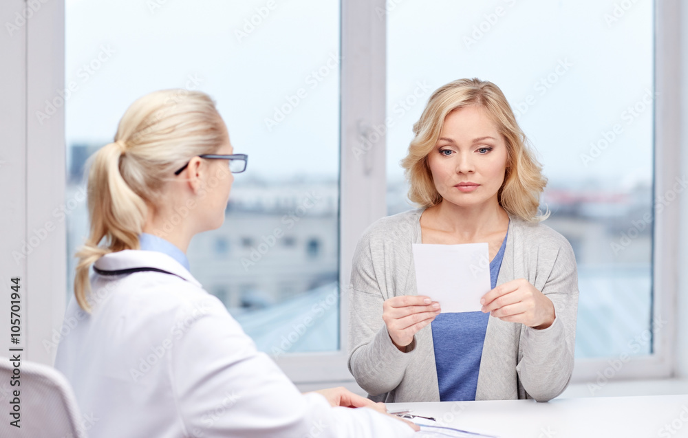 doctor giving prescription to woman at hospital