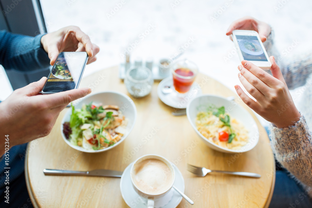 close up of couple picturing food by smartphone close up of couple picturing food by smartphone
