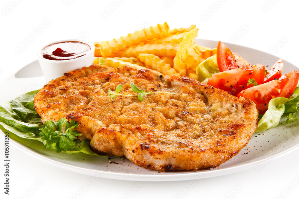 Fried pork chop, French fries and vegetables