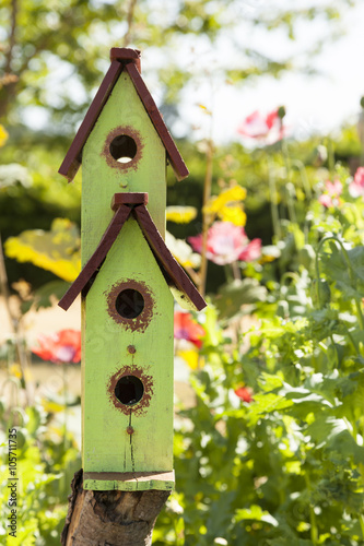 A cute, rustic birdhouse in a country flower garden