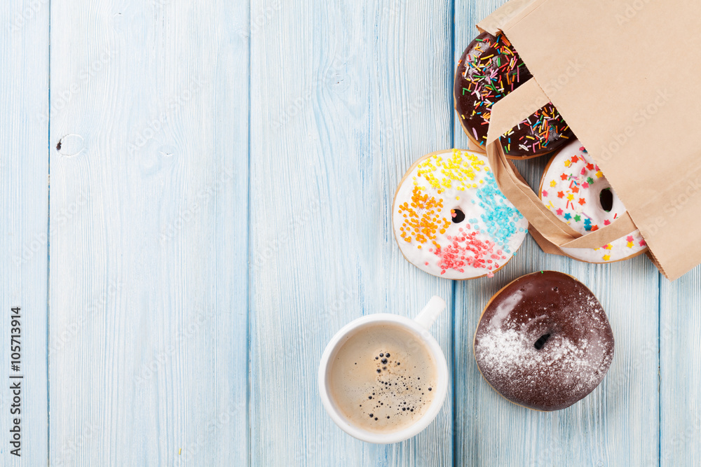 Colorful donuts in paper bag and coffee cup Colorful donuts in paper bag and coffee cup