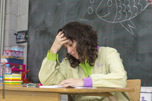 Tired teacher in classroom.. photo