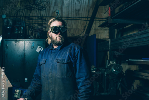 Man with beard and goggles in workplace