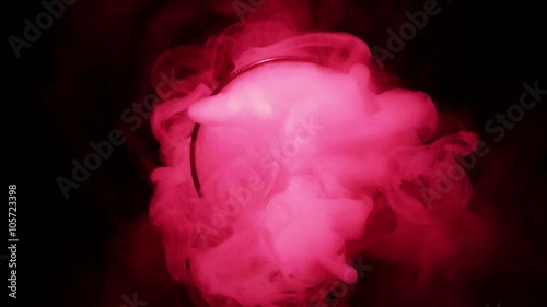 Clubs of Infernal Pink Thick Haze Coming Out of Bulb in the Pitch Darkness Top View