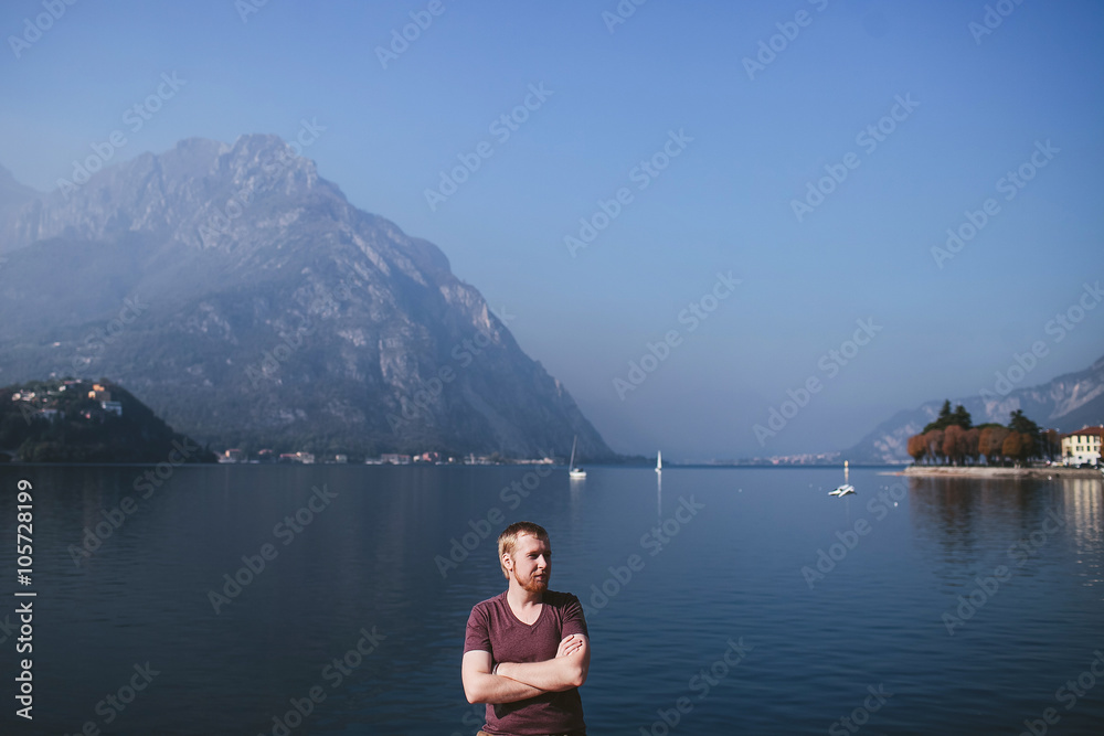 bearded man on the background of a mountain lake Como