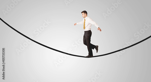 Happy businessman walking on rope