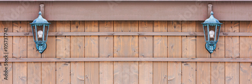 Old fashioned lantern on a brown wooden wall.