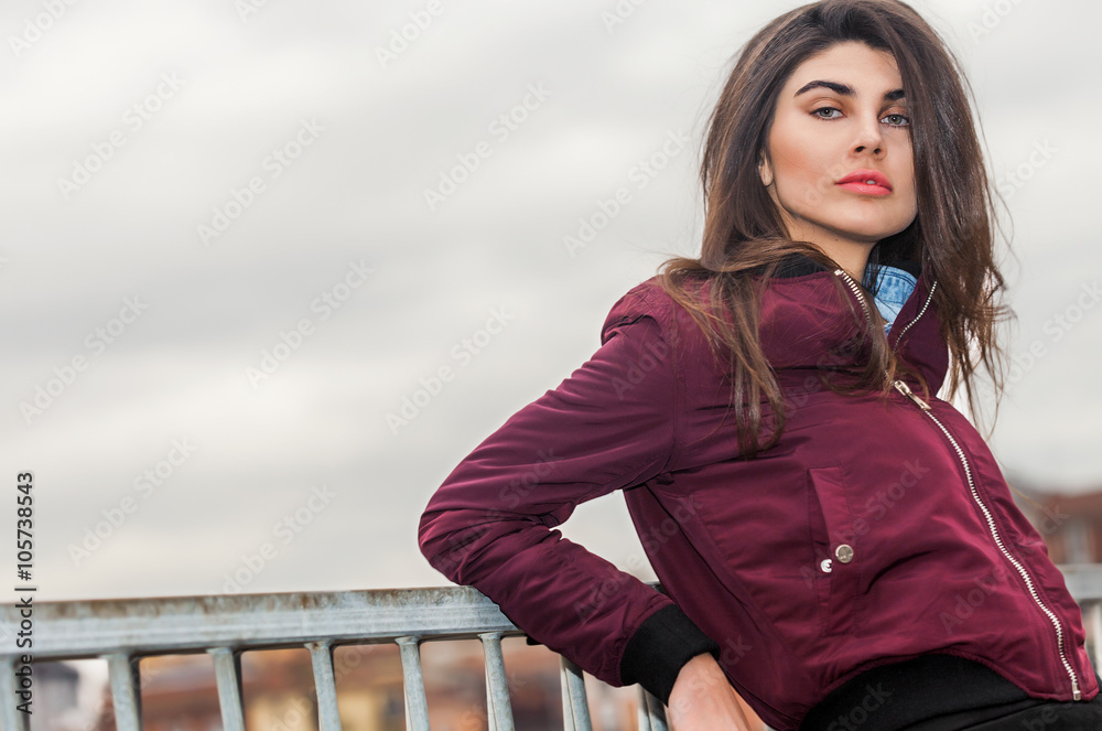 Woman portrait in the city wearing burgundy jacket