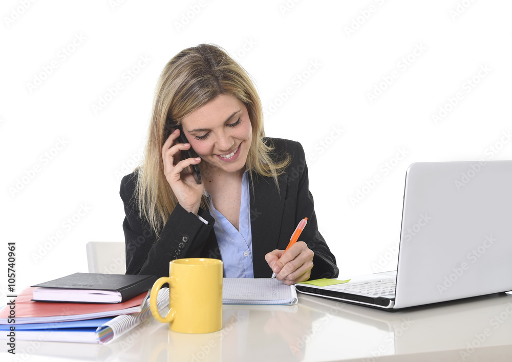happy Caucasian blond business woman working talking on mobile phone at office computer desk happy Caucasian blond business woman working talking on mobile phone at office computer desk