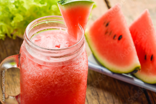 Healthy watermelon smoothie on a wood background and slices of w