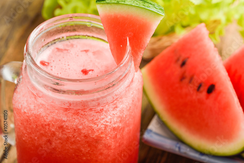 Healthy watermelon smoothie on a wood background and slices of w