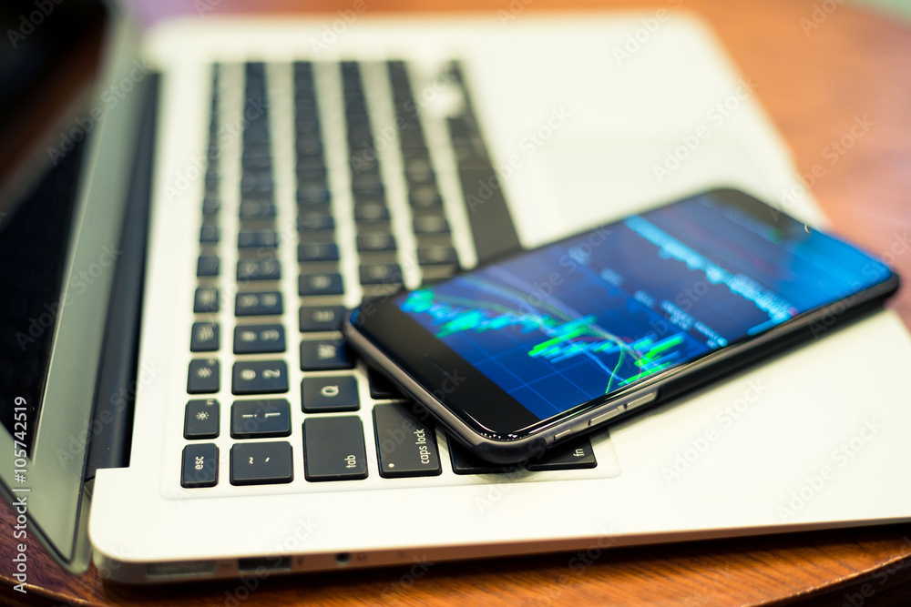 Laptop computer and cellphone with Stock market chart Laptop computer and cellphone with Stock market chart