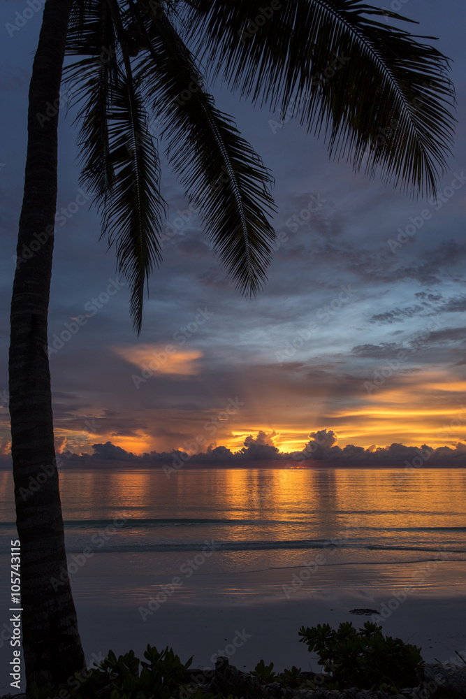 Colorful and beautiful clouds at sunrise with reflection in ocean in Zanzibar, Tanzania.
