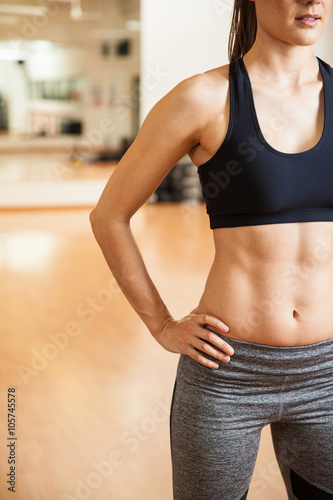 Strong woman with toned abs at a gym