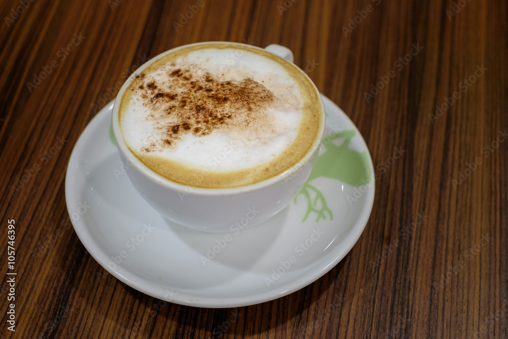 White cup containing hot cappuccino coffee on table White cup containing hot cappuccino coffee on table