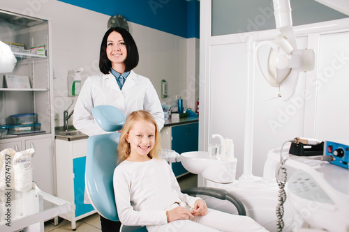 Young handsome dentist treats tooth child  a woman dentist