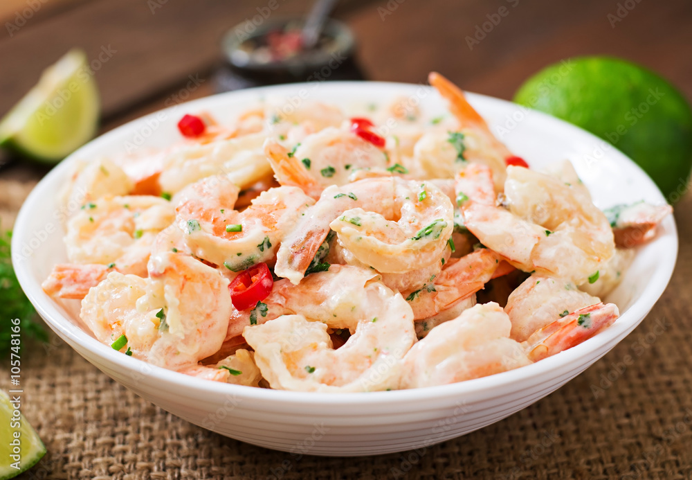 Shrimp in a creamy garlic sauce with parsley and lime in white bowl Shrimp in a creamy garlic sauce with parsley and lime in white bowl