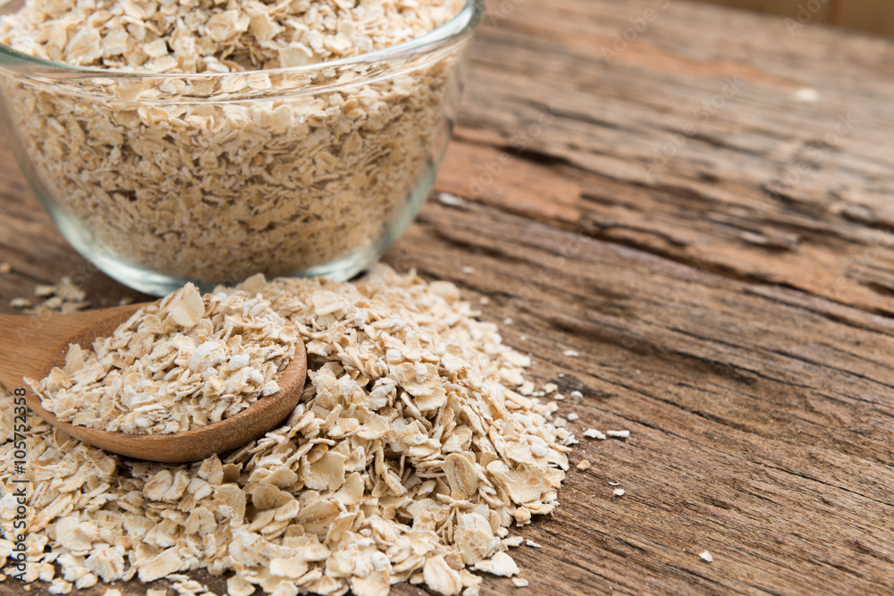 Dry rolled oat flakes oatmeal on old wooden table