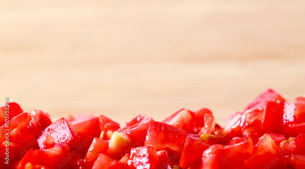 fresh diced / chopped red tomatoes on blurred wood background fresh diced / chopped red tomatoes on blurred wood background