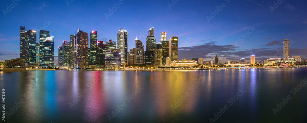 Naklejka premium Colorful Singapore business district skyline after sun set at Marina Bay. Panoramic image.