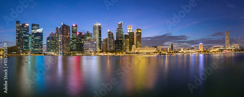 Colorful Singapore business district skyline after sun set at Marina Bay. Panoramic image.