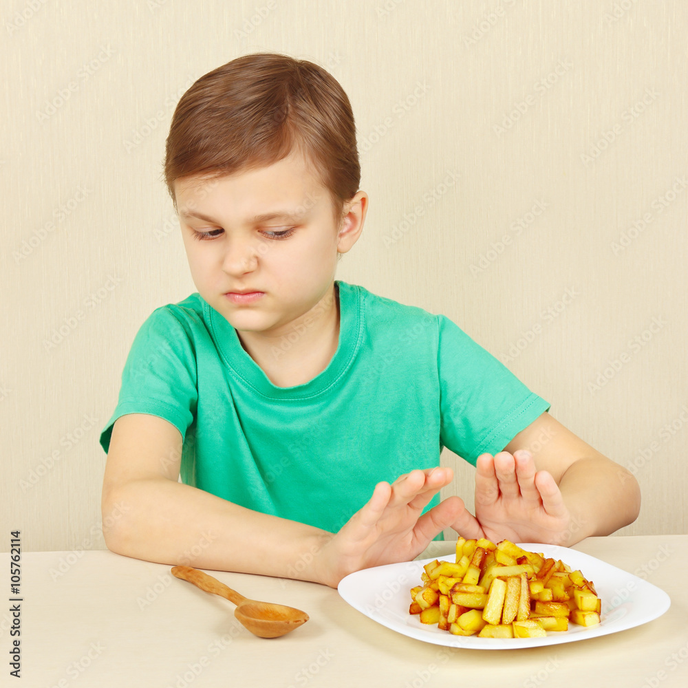 Little boy does not want to eat a fried potatoes Little boy does not want to eat a fried potatoes