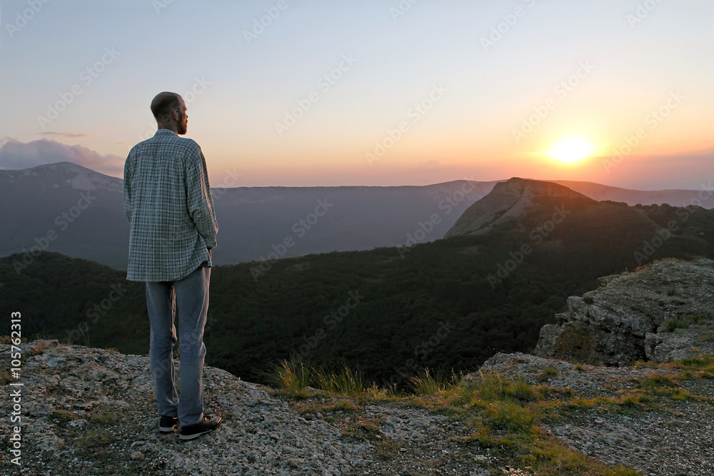 Bearded man in jeans looking at the sunset in the mountains soltse Bearded man in jeans looking at the sunset in the mountains soltse