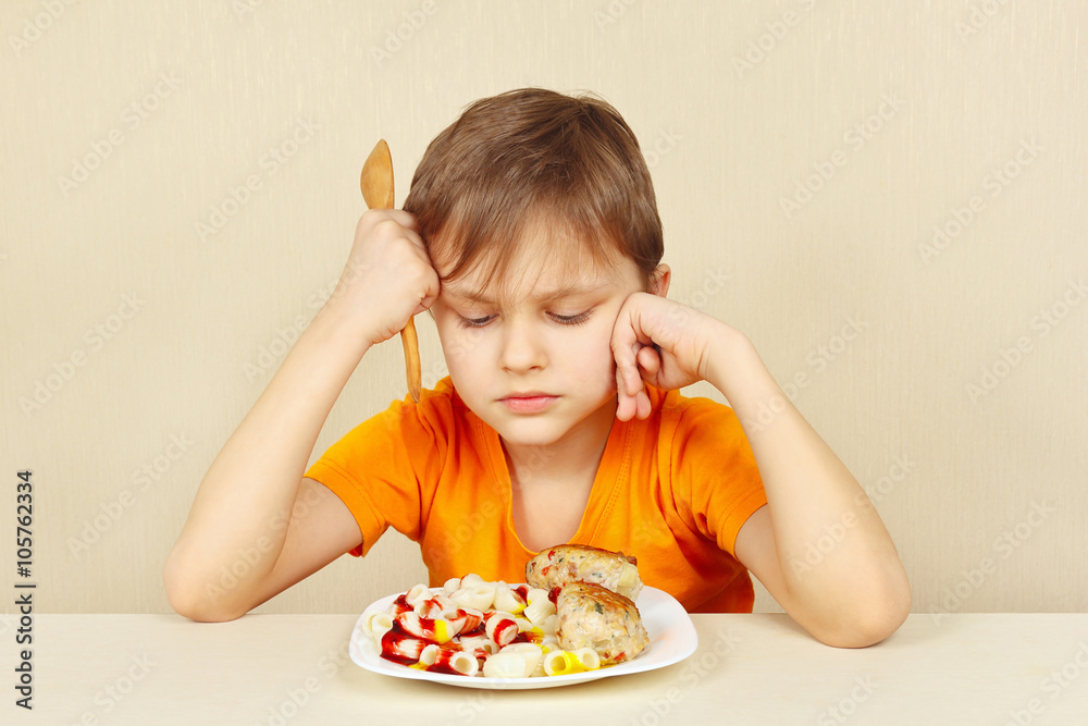 Little discontented boy does not want to eat a pasta with cutlet Little discontented boy does not want to eat a pasta with cutlet
