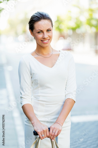 Business woman pulling suitcase bag walking in city © Sergey Nivens