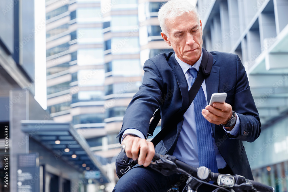 Successful businessman on bicycle with mobile phone Successful businessman on bicycle with mobile phone