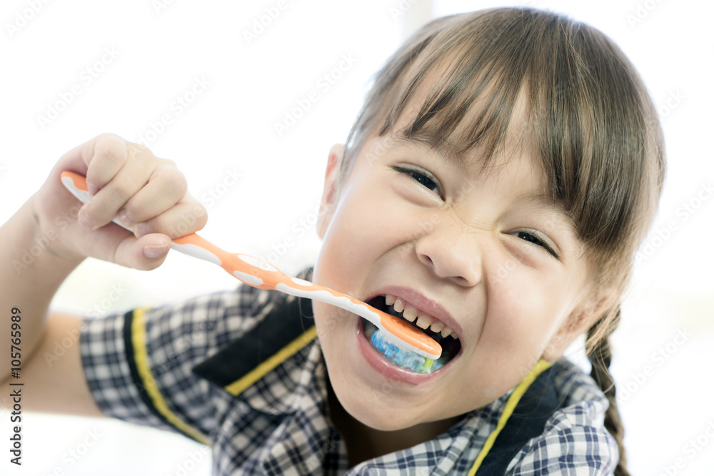 a school uniform little girl is brushing teeth a school uniform little girl is brushing teeth