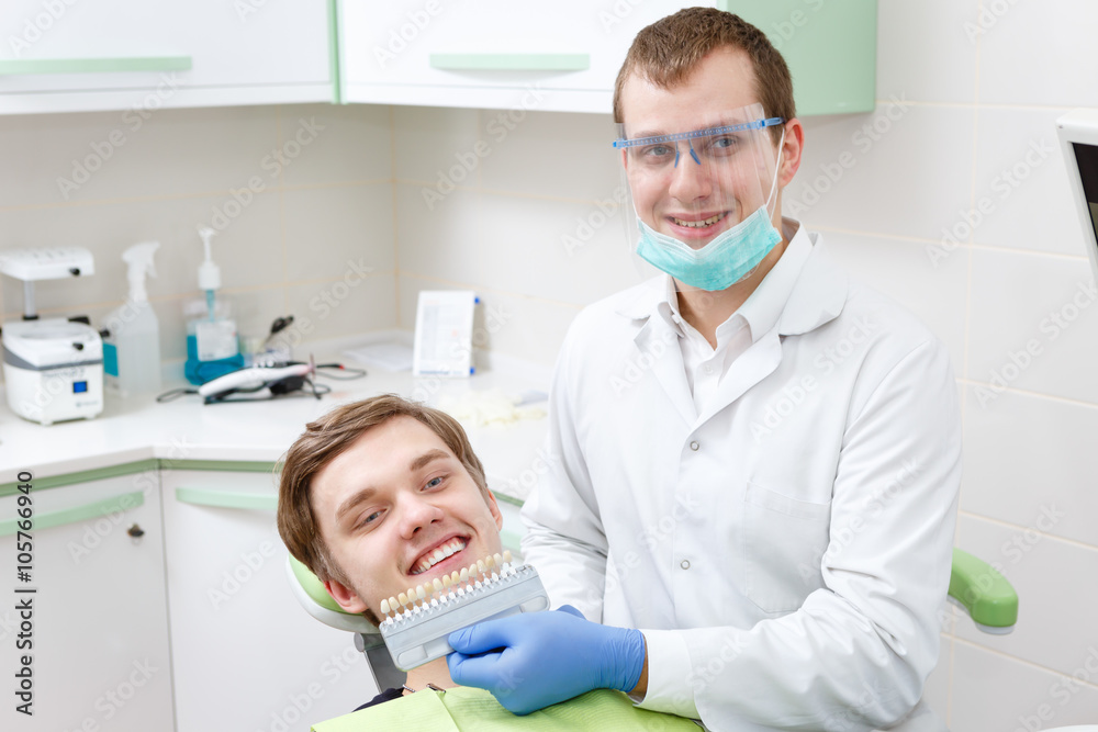 Fototapeta premium Young Dentist man student comparing teeth whitening of him patient in dental clinic