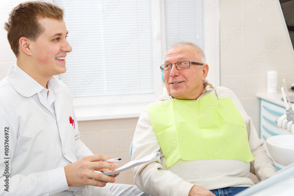 Elderly man on a review of a dentist, sitting in a chair Elderly man on a review of a dentist, sitting in a chair