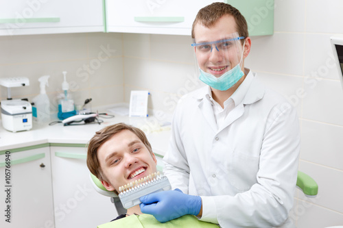 Young Dentist man student comparing teeth whitening of him patient in dental clinic