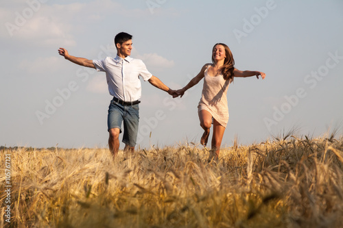 Young couple walking through wheat field