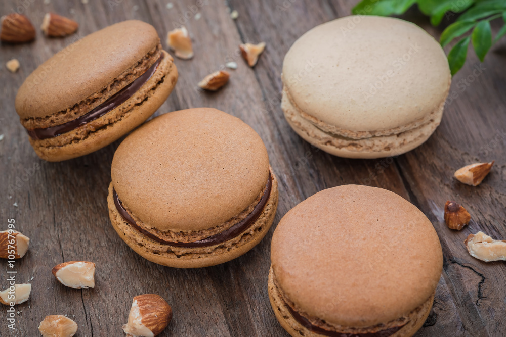 French macaroons and almonds on wooden table French macaroons and almonds on wooden table