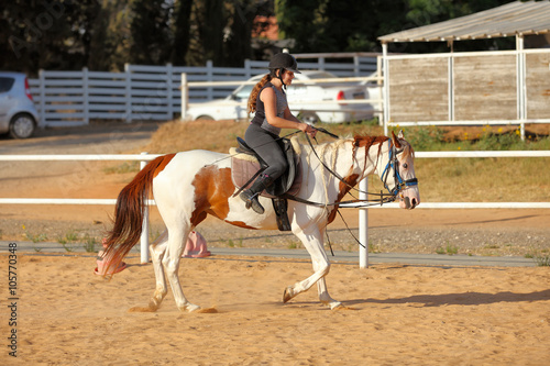 young girl is riding a horse