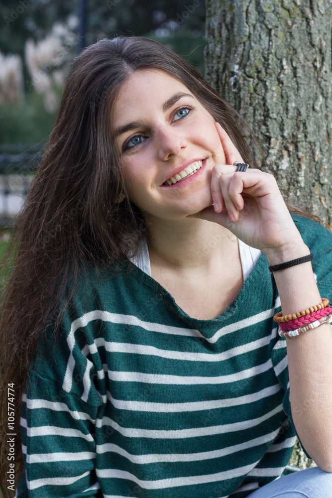 Blue-eyed young model posing in a fashion shoot in the park. 