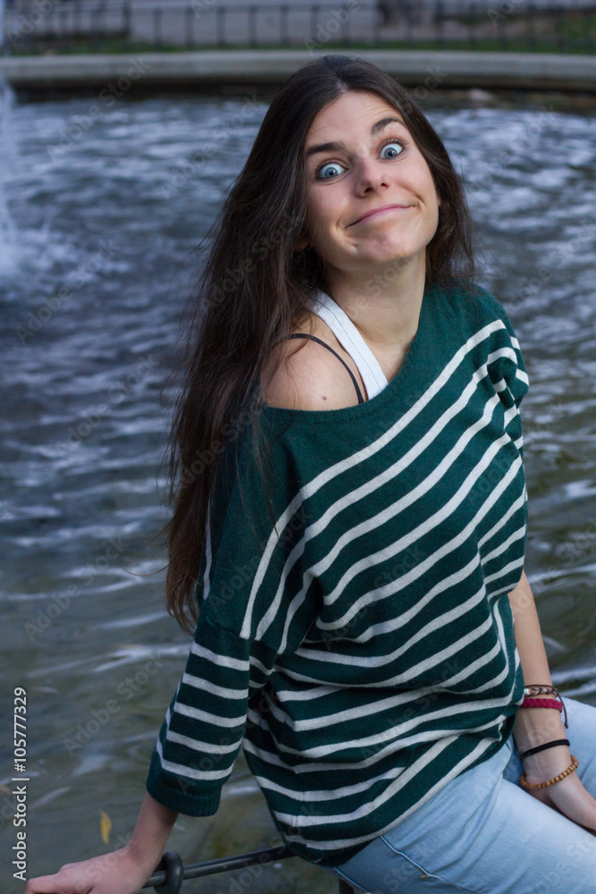 Blue-eyed young model posing in a fashion shoot in the park. She is making a funny face in surprise. Blue-eyed young model posing in a fashion shoot in the park. She is making a funny face in surprise.
