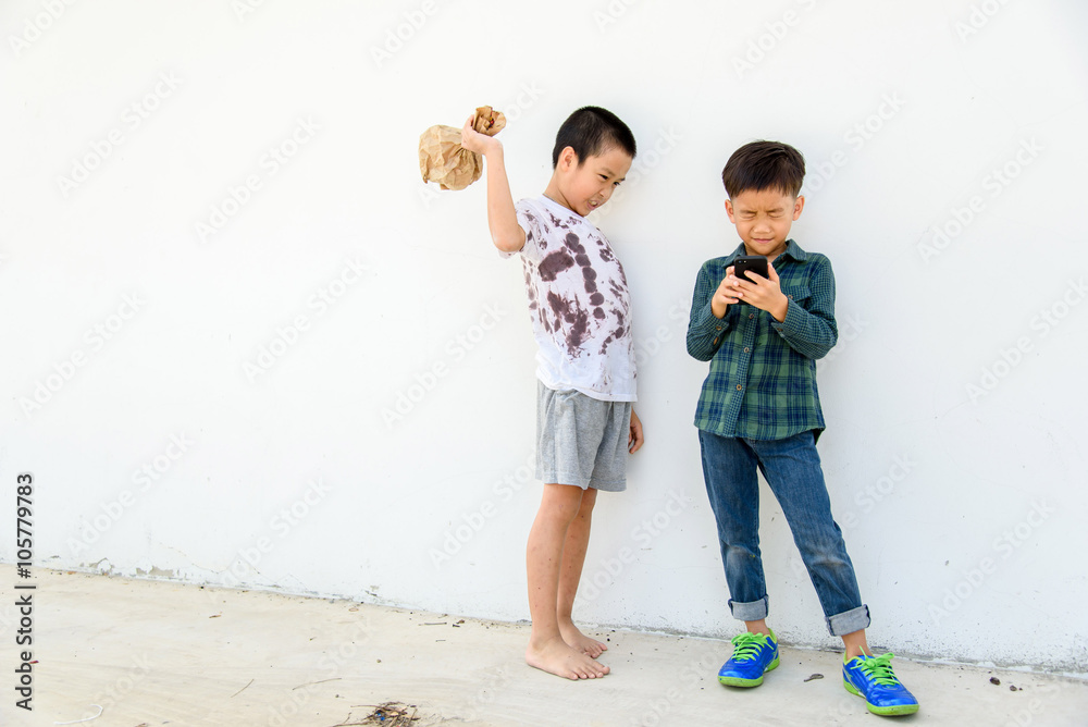 Young boy play smartphone compare with poor boy