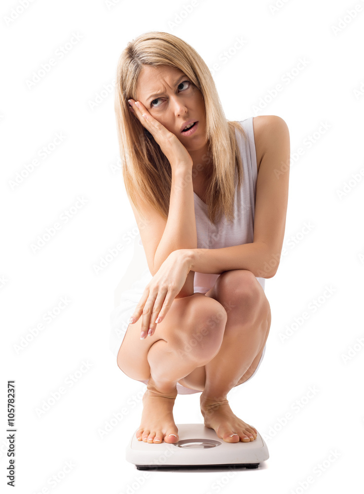 Obraz premium Sad woman on weight scale