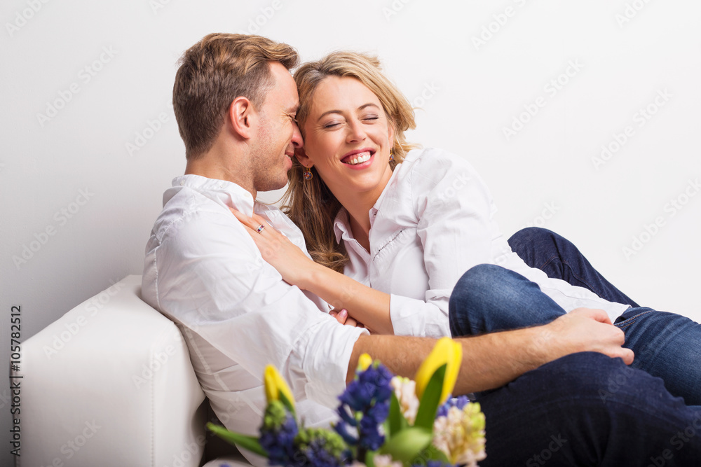 Happy couple cuddling on couch