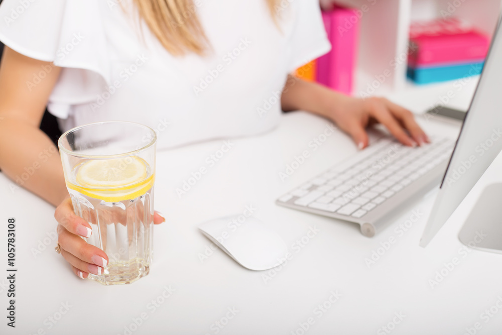 Woman having lemon water while working Woman having lemon water while working